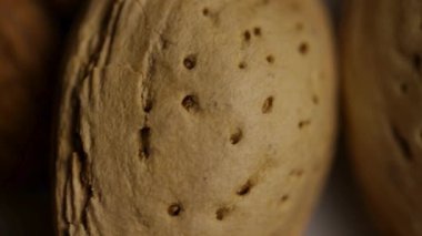 Çiğ badem tanecikleri ve kabukların üzerindeki makro paneller deri dokusunu ve sağlıklı abur cubur malzemelerini gösteriyor.