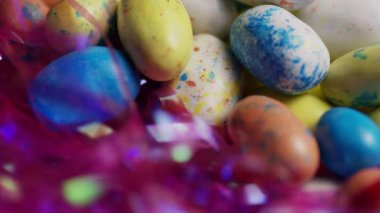 Renkli benekli paskalya yumurtaları pembe süs yuvasında şekerleme dönüşümlü tatlı tatil ziyafeti dekorasyonu arka planında