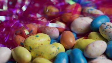 Renkli benekli paskalya yumurtaları pembe süs yuvalarında dönüyorlar. Tatlı bayram ziyafeti dekorasyonu arka plan şenlik kutlaması.