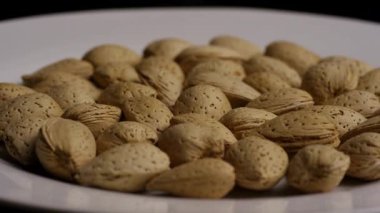 Beyaz Tabakta Dönen Kabuklu Organik Badem Fındıkları Düşük Açı Görünümü Sağlıklı Meyveli Atıştırmalık Sunumu ve Doğal Gıda Dokuları Konsepti