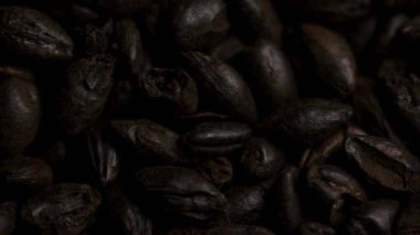 Koyu bir çevrede dönen kavrulmuş siyah arpa taneciklerinin aşırı yakın görüntüsü tarımsal arka plan organik sağlıklı mısır gevreği.