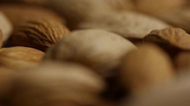 Makro paneller, kabuklu badem parçalarının üzerine doğal kahverengi dokusunu sağlıklı organik fındık çerezi arka planını gösteriyor.