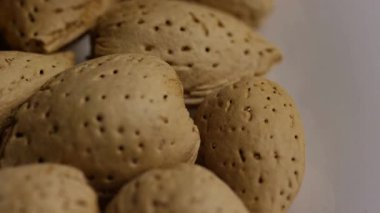 Yüksek açılı, kabuklu badem yığını beyaz arka planda sağlıklı organik çerez besin maddeleri.