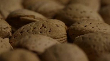 Kabuklu badem yığınını yakından incele. Doğal kahverengi doku. Sağlıklı organik vejetaryen çerez arka planı.