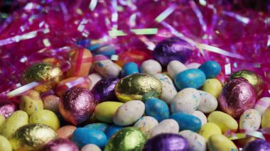 Dönüşümlü karışık paskalya ziyafetleri arasında folyo çikolata yumurtaları ve tatil partisi için pembe yuvada benekli jöle şekerlemeleri de var.