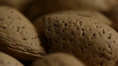 Kahverengi badem fıstığı kabukları üzerindeki gözenekli dokunun aşırı büyük detayı yumuşak ve sıcak ışıklandırmayla yüksek kaliteli yemek görüntülerinde doğal desenleri vurguluyor.