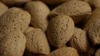 Detaylı doku ve doğal desenleri gösteren kabuklu çiğ badem fıstıklarının makro görüntüsünü çok yakından çek.