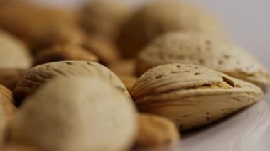 Doğal dokuyu ve detaylı organik kalıpları gösteren gözenekli kabuklu çiğ badem fıstıklarının makro görüntüsünü aşırı yakın çekim.