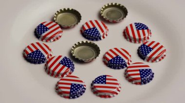 Amerikan bayrağı tasarımlı metal bira şişesi kapakları vatanseverlik kutlamaları ve bağımsızlık günü parti konsepti için beyaz tabakta daire şeklinde dizilmiş.