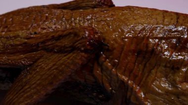 Kırmızımsı kahverengi derisi ve kırmızı arka planda pişmiş ördek etinin bacağı boyunca yiyecek reklamı için aşırı yakın çekim.