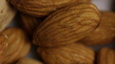 Kahverengi kabuklu ve kabuksuz badem fıstıklarının desenli yüzeyinde Macro Panning Çekimi Ayrıntılı Çukur Derileri ve Kabukları