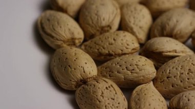 Sağlıklı organik gıda dokusu için bütün bademleri sert desenli bej kabuklarla kapatıyoruz.