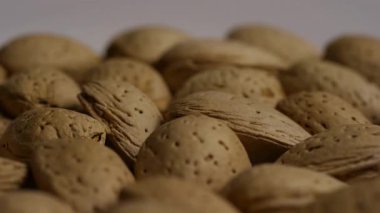 Aşırı derecede yakın açıda, sağlıklı atıştırma, doğal gıda dokusu ve vejetaryen beslenme için dönen kabuklu badem kabuklarının düşük açılı görüntüsü