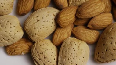Kabuklu çiğ badem çekirdekleri ve badem kabuğu karışımı çeşitli çerez ve diyet kavramları ve sağlıklı beslenme için dönüyor.