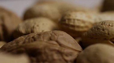 Sağlıklı beslenme kavramları için fıstık, badem ve ceviz de dahil olmak üzere kabuklarda karışık fındık görüntülerini çok yakından inceleyin.