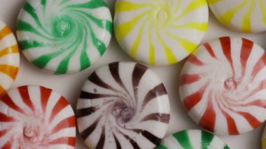 Bayram tatlısı ve şeker tatlısı kavramları için beyaz zemin üzerinde dönen renkli spiral nane şekeri çeşitleri