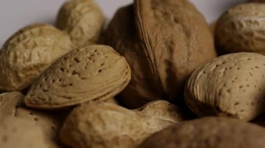 Cevizli badem ve fıstıkların sağlıklı atıştırma ve vejetaryen beslenme kavramları için döndüğü kabuklu karışık fındık çeşitleri.
