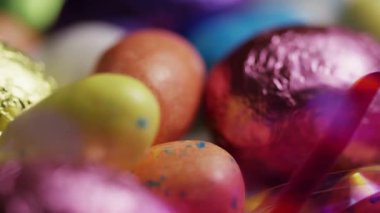 Renkli folyo karışımı çikolata ve benekli paskalya yumurtaları bahar tatili kutlamaları ve parti geçmişleri için süslemeli.