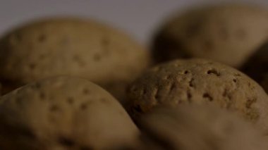 Kabuklu badem cevizi kabuklarının detaylandırılmış derinliği kaba desen ve doğal kahverengi renk yığını abur cuburu vurguluyor.