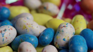 Renkli benekli şeker yumurtaları Paskalya bayramı kutlamaları için canlı mavi ve pembe renklerle dönüşümlü olarak tatlı tatlı tatlı partisi yemeği ikram ediyor.
