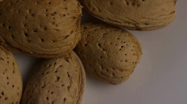 Aşırı yakın çekim çiğ badem fıstıklı kabuklar yavaş yavaş döner gözenekli doku ve doğal kahverengi renk gösterir