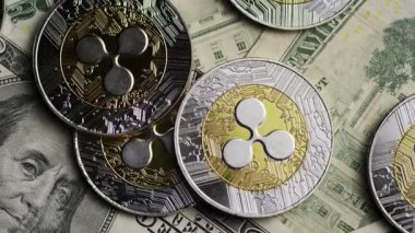 Dijital finans sembolizmini vurgulayan yumuşak yönelimli aydınlatma altında kağıt para üzerinde dinlenen çoklu metalik kripto para biriminin görünümünü kapat