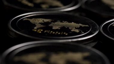 Metalik dijital para sikkeleri, karanlık modern finansal konsept sahnesine ışığı yansıtan yakın bir şekilde düzenlenmiştir.