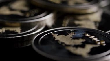 Küresel kripto para piyasaları ve uluslararası finans teknolojisi sistemlerini işaret eden dünya haritası kabartmalı dijital sikkeler boyunca sinematik makro tavalar.