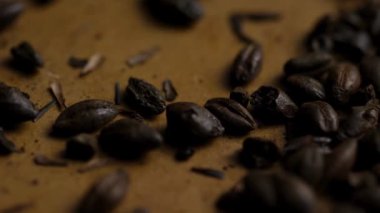 Düz zemine saçılmış kahve çekirdeklerinin makro görüntüsü çatlakların dokusunu ve kavrulmuş tonları ortaya çıkarıyor.