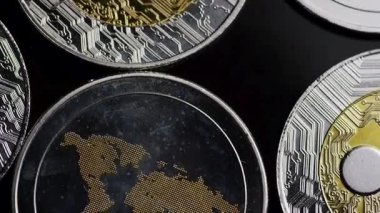 Yığılmış metalik paraların ayrıntılı makro görünümü, işlemeli kenarları ve koyu ayarlardaki yansıtıcı gölgeleri gösterir