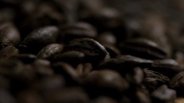 Sığ odak makro kahve çekirdekleri koyu karamsar doku arkaplanı oluşturuyor.