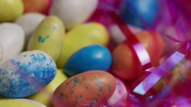 Renkli boyalı Paskalya yumurtaları parlak ışık altında şeffaf dekoratif ambalajlar içinde sıralanmış.