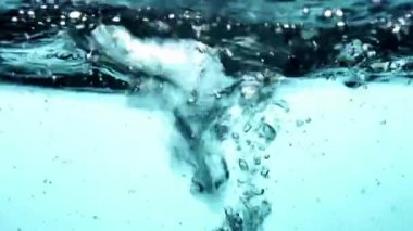 Yoğun kabarcıklarla turkuaz mavi su yüzeyi ve dinamik eylemle canlı sualtı soyut sahnesi oluşturur.