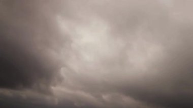 Soft grey storm clouds moving and swirling creating moody atmospheric cloudscape with dramatic overcast weather patterns