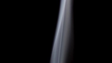 Tek bir ince beyaz duman akıntısı sürekli olarak dipten yükselir ve pürüzsüz bir dikey çizgi yaratır..