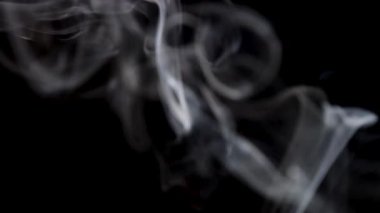 Pürüzsüz ve sürekli beyaz duman, siyah izole edilmiş arka planda yumuşak bir akıntıyla yukarıya doğru akar..