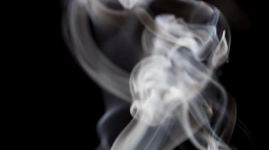 Sürekli beyaz bir duman akışı, koyu bir arkaplana karşı dikey bir çizgide sürekli olarak yukarı doğru akar..