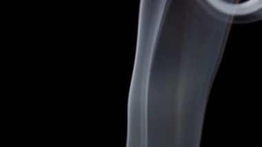 Beyaz duman dalgalanır ve çerçevede siyah bir zemine doğru yuvarlanır dramatik bir hareket yaratır..