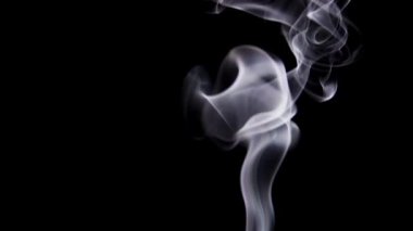 Yumuşak beyaz duman yumuşak ve sakin bir hareketle siyah bir zemine doğru yavaşça hareket eder..