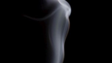 Beyaz duman, karanlığın içinde hipnotik desenler oluşturan büyüleyici bir dansla yukarı doğru kıvrılır..