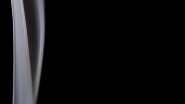 Pürüzsüz beyaz duman, saf siyah üzerinde zarif bir hareketle sürekli akıyor..