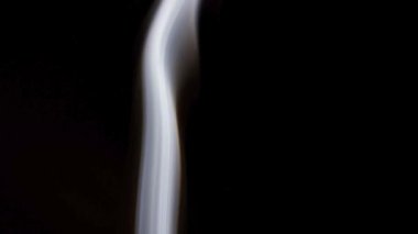 Siyah arka planda yoğun bir varlık ile yoğun beyaz duman dramatik bir şekilde hareket eder.