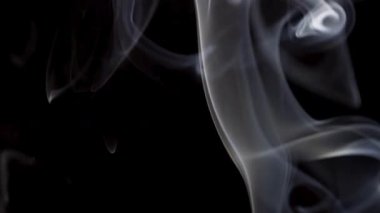 Aydınlık ve havadar beyaz duman dikey yükselir ve zarif bir hareketle karanlık bir boşlukta yavaşça kaybolur..