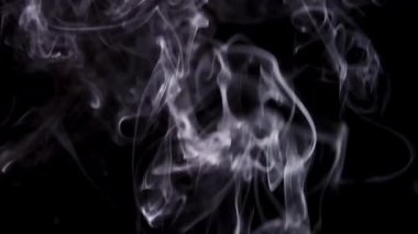 Kalın ve kaotik beyaz duman bulutları yükselir ve çerçeveyi karmaşık dokular ve siyah zemine karşı hızlı dönen hareketlerle doldurur.