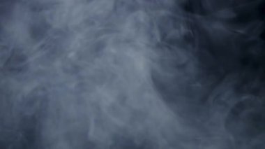 Gizemli ve atmosferik görsel efekt sekansları için karanlık bir zemin üzerinde dalgalanan ve sürüklenen sinematik yoğun beyaz sis ve duman bulutları