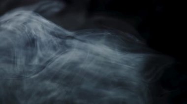Zarif geçişler ve yüksek kaliteli film projelerinde atmosfer derinliği için ince beyaz buhar siyah bir zemin üzerinde sürükleniyor.