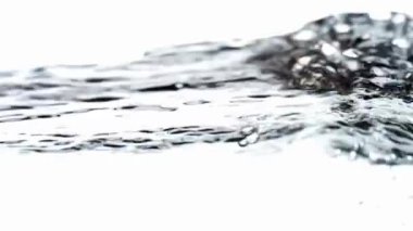 Yüksek hızlı bir stüdyo çekimi kristal berrak su dalgalar yaratır ve kabarcıklarla su sıçratır. Saf beyaz arka planda güzel, yavaş çekim detaylarıyla hareket eder.