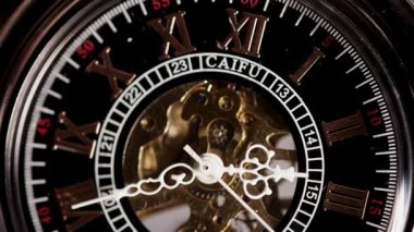 Klasik Roma sayılı saat işaretlerini süpüren hareketli mekanik dişliler ve zarif beyaz ellerle süslü iskelet bir cep saatinin tam kare görüntüsü