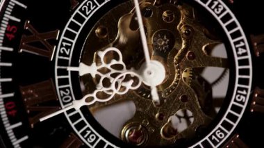 Çalışan bir iskelet saat mekanizmasının detaylı gözlemi pirinç dişlilerin ve kaçış çarklarının lüks bir zaman tutma cihazı içinde sürekli hareket ettiğini vurguluyor.