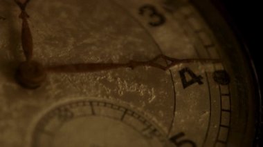 Ekstrem makro. Tozlu antika bir cep saati kapağı. Sayıları gösteriyor ve sıcak bir sepia klasik film estetiği ve ruh hali ile ellerini hareket ettiriyor.